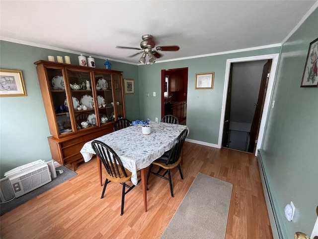 42 Saint Marks Ave, Freeport, NY 11520 - dining area with a baseboard radiator, a ceiling fan, wood finished floors, ornamental molding, and baseboards