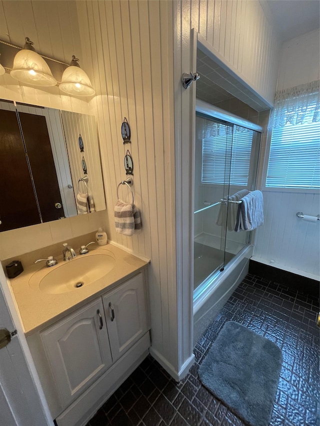 42 Saint Marks Ave, Freeport, NY 11520 - full bath with wooden walls, shower / bath combination with glass door, vanity, and brick patterned floors