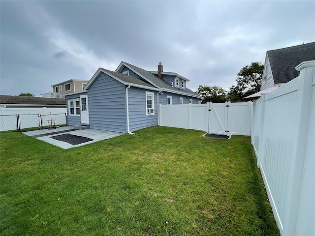 42 Saint Marks Ave, Freeport, NY 11520 - rear view of house featuring a gate, a patio area, roof with shingles, and a chimney