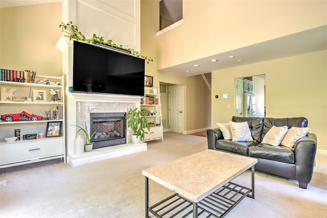 17 Gettysburg Dr Unit 17, Port Jefferson Station, NY 11776 - living room with carpet flooring, a tiled fireplace, baseboards, and a high ceiling