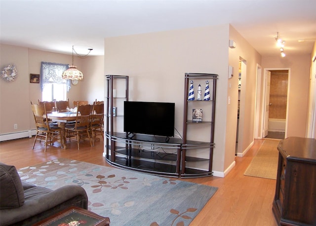 263 River Ave Unit 52, Patchogue, NY 11772 - living area featuring wood finished floors, a baseboard radiator, baseboards, and a chandelier