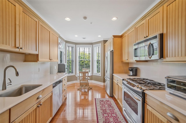 23 Sonata Ct, Lake Grove, NY 11755 - kitchen with stainless steel appliances, a sink, baseboards, light countertops, and light wood-type flooring