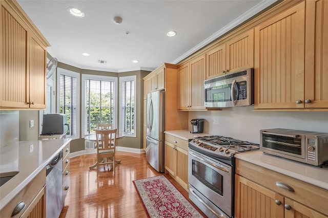 23 Sonata Ct, Lake Grove, NY 11755 - kitchen with appliances with stainless steel finishes, light countertops, ornamental molding, baseboards, and light wood-type flooring
