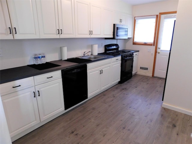 7 Audrey Ln, Commack, NY 11725 - kitchen featuring black appliances, dark countertops, wood finished floors, and white cabinets
