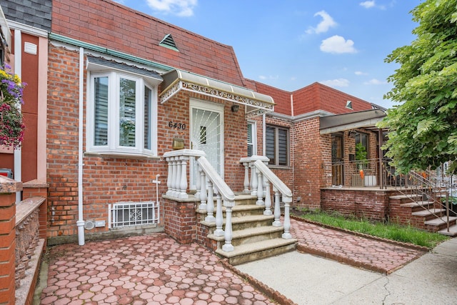 64-30 73rd Pl, Middle Village, NY 11379 - view of front of home featuring mansard roof, brick siding, and a shingled roof