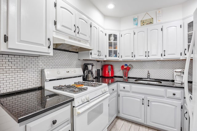 64-30 73rd Pl, Middle Village, NY 11379 - kitchen featuring white gas range, a sink, under cabinet range hood, white cabinetry, and glass insert cabinets