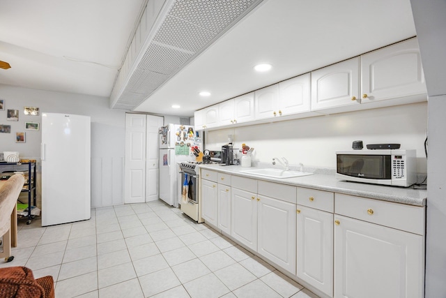 64-30 73rd Pl, Middle Village, NY 11379 - kitchen featuring white appliances, a sink, white cabinetry, light countertops, and light tile patterned floors