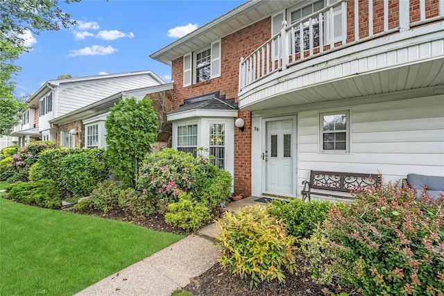 38 The Mews, Syosset, NY 11791 - property entrance with a balcony and brick siding