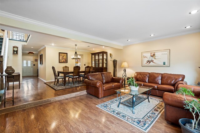 38 The Mews, Syosset, NY 11791 - living room with wood finished floors, ornamental molding, recessed lighting, baseboards, and a chandelier