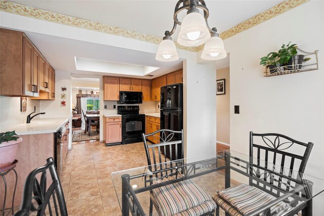 38 The Mews, Syosset, NY 11791 - kitchen with black appliances, light countertops, a tray ceiling, and a sink