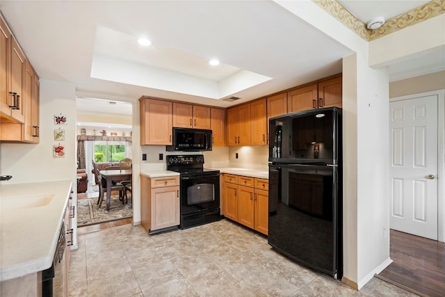 38 The Mews, Syosset, NY 11791 - kitchen featuring black appliances, a tray ceiling, light countertops, a sink, and recessed lighting