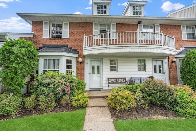 38 The Mews, Syosset, NY 11791 - view of front of house featuring a balcony, a porch, and brick siding