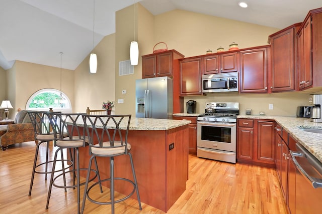 390 Lakeside Rd, Newburgh, NY 12550 - kitchen with appliances with stainless steel finishes, high vaulted ceiling, a center island, light wood finished floors, and a kitchen bar