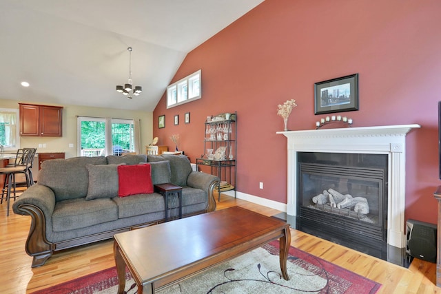 390 Lakeside Rd, Newburgh, NY 12550 - living area featuring light wood finished floors, a chandelier, high vaulted ceiling, a fireplace with flush hearth, and baseboards