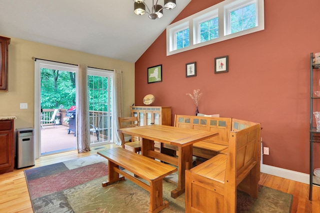 390 Lakeside Rd, Newburgh, NY 12550 - dining room featuring high vaulted ceiling, a chandelier, light wood-type flooring, and baseboards