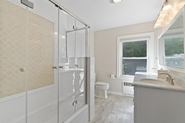 61 Tamarack Rd, Rye Brook, NY 10573 - full bathroom featuring radiator heating unit, toilet, healthy amount of natural light, and wood finished floors