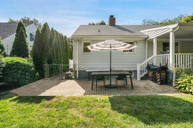 61 Tamarack Rd, Rye Brook, NY 10573 - rear view of house with a chimney, a patio area, and a gate