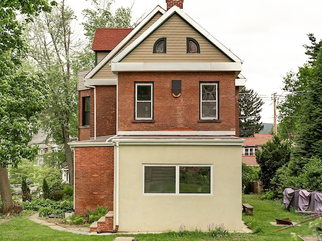 511 Grand Ave, Newburgh, NY 12550 - rear view of house with a chimney, brick siding, a yard, and stucco siding