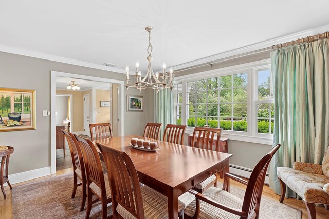 2 Shady Meadow Ln, Syosset, NY 11791 - dining room featuring a chandelier, ornamental molding, light wood-style flooring, baseboards, and a baseboard heating unit