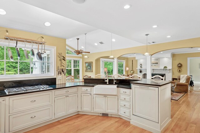 2 Shady Meadow Ln, Syosset, NY 11791 - kitchen with arched walkways, open floor plan, a sink, dark countertops, and stainless steel gas cooktop