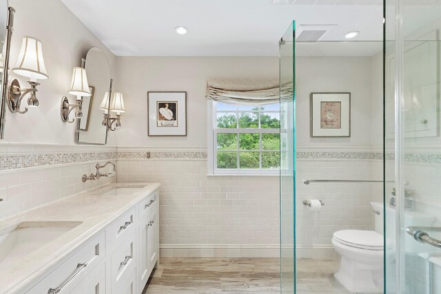 2 Shady Meadow Ln, Syosset, NY 11791 - full bathroom featuring tile walls, double vanity, wainscoting, toilet, and a shower stall