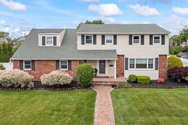 6 W Shore Rd, Bay Shore, NY 11706 - view of front of house featuring brick siding, a front yard, and a shingled roof
