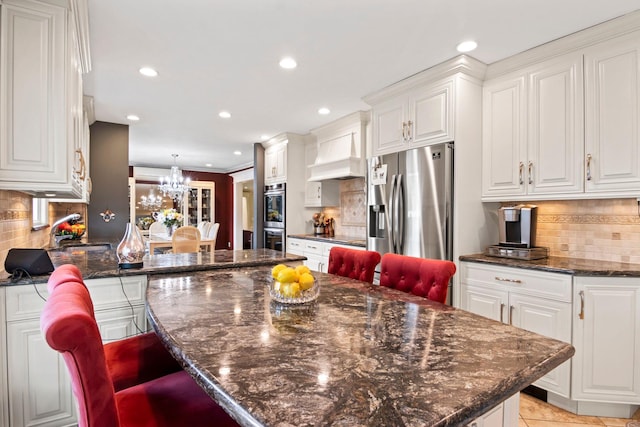 6 W Shore Rd, Bay Shore, NY 11706 - kitchen featuring appliances with stainless steel finishes, a chandelier, white cabinetry, a breakfast bar, and recessed lighting