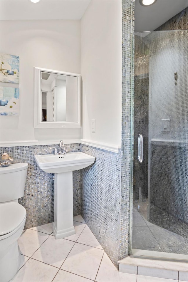 6 W Shore Rd, Bay Shore, NY 11706 - bathroom featuring tile walls, toilet, a stall shower, a wainscoted wall, and tile patterned floors