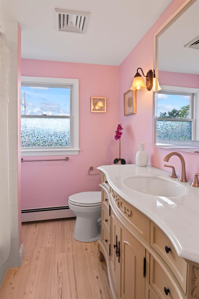6 W Shore Rd, Bay Shore, NY 11706 - bathroom with a baseboard heating unit, plenty of natural light, wood finished floors, and toilet
