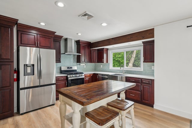 872 Main St, Farmingdale, NY 11735 - kitchen with stainless steel appliances, wall chimney range hood, a sink, dark brown cabinets, and light wood-type flooring