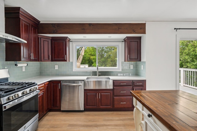 872 Main St, Farmingdale, NY 11735 - kitchen featuring stainless steel appliances, wall chimney range hood, a sink, and dark brown cabinets