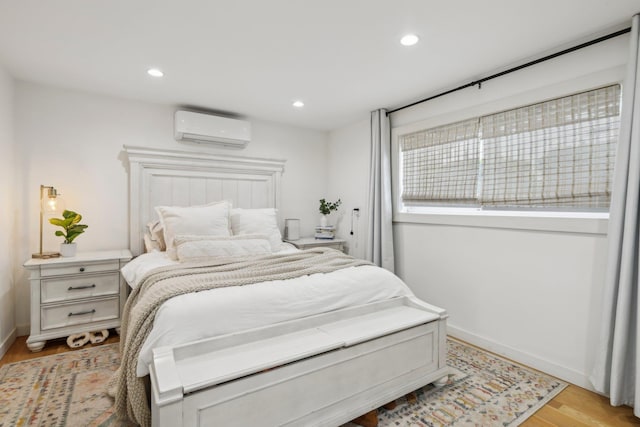 872 Main St, Farmingdale, NY 11735 - bedroom with an AC wall unit, light wood finished floors, recessed lighting, and baseboards