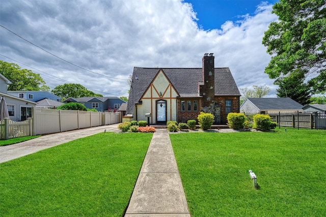 240 Tyrconnell Ave, Massapequa Park, NY 11762 - english style home featuring a chimney, brick siding, and a shingled roof