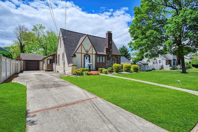 240 Tyrconnell Ave, Massapequa Park, NY 11762 - tudor-style house with concrete driveway, a chimney, an outdoor structure, and a shingled roof