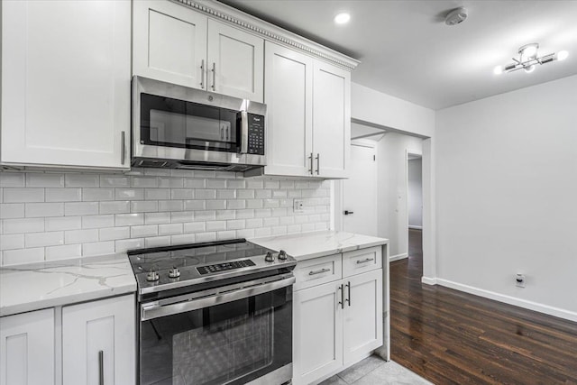 855 Winter Ave, Uniondale, NY 11553 - kitchen featuring appliances with stainless steel finishes, wood finished floors, baseboards, and light stone countertops