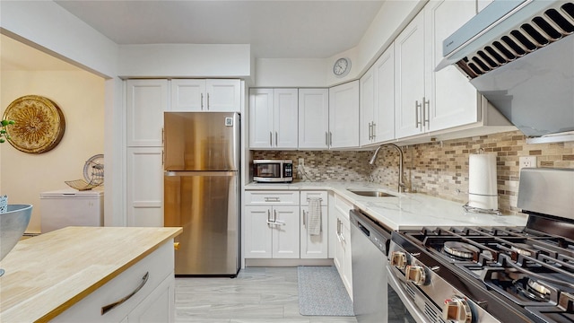 37-40 61st St, Woodside, NY 11377 - kitchen with stainless steel appliances, decorative backsplash, light stone counters, white cabinetry, and ventilation hood