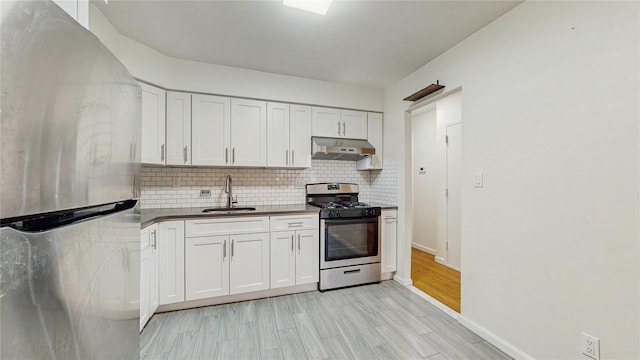 37-40 61st St, Woodside, NY 11377 - kitchen featuring stainless steel appliances, under cabinet range hood, decorative backsplash, and white cabinets