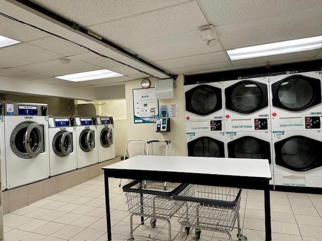 86-10 34th Ave Unit 624, Jackson Heights, NY 11372 - shared laundry room with estacked washer and dryer, washer and dryer, and tile patterned flooring