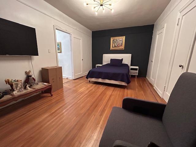 86-10 34th Ave Unit 624, Jackson Heights, NY 11372 - bedroom with wood finished floors and a chandelier