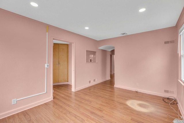 5 E Walnut St, Long Beach, NY 11561 - empty room featuring arched walkways, baseboards, recessed lighting, light wood-style flooring, and ornamental molding