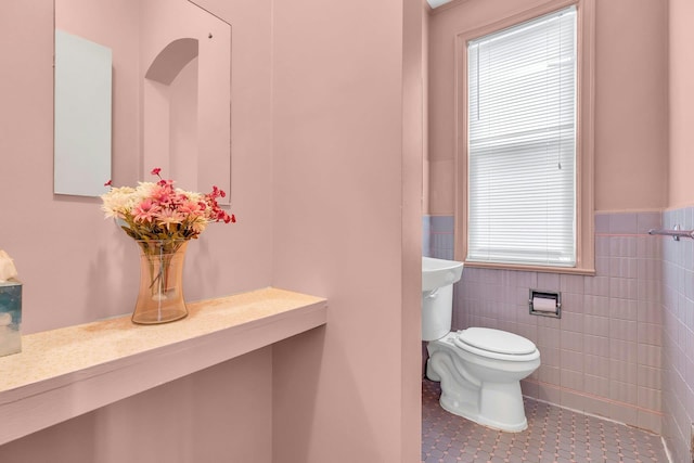 5 E Walnut St, Long Beach, NY 11561 - half bathroom featuring tile patterned flooring, toilet, a wainscoted wall, and tile walls