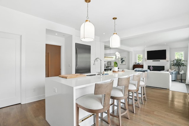 27 Lavender Ln, Rye Brook, NY 10573 - kitchen with built in fridge, light countertops, wood finished floors, decorative light fixtures, and a breakfast bar area