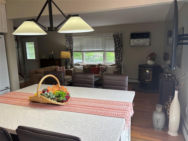 6 Windmill Rd, Poughkeepsie, NY 12601 - dining space with wood finished floors, a wood stove, a wall mounted AC, and a baseboard heating unit