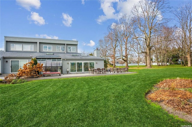33 Harbour Dr, Blue Point, NY 11715 - back of house featuring a chimney, a lawn, a patio area, and roof with shingles