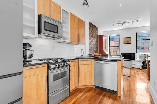 161 W 133rd St, New York Manhattan, NY 10030 - kitchen with appliances with stainless steel finishes, a peninsula, dark countertops, light wood-style flooring, and recessed lighting