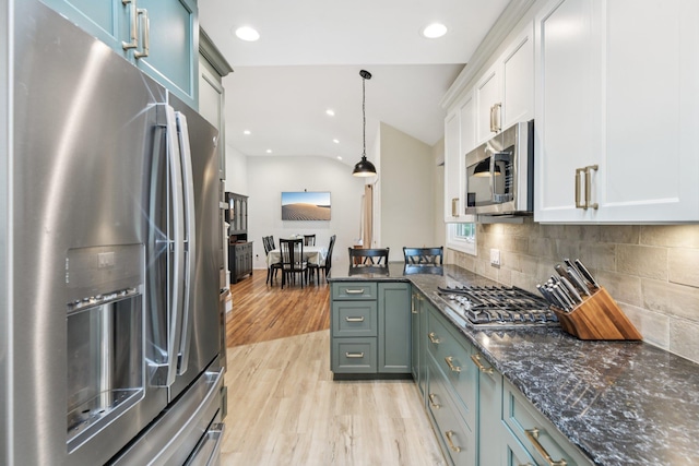 422 Old Bridge Rd, Northport, NY 11768 - kitchen with appliances with stainless steel finishes, light wood-style floors, tasteful backsplash, white cabinetry, and pendant lighting