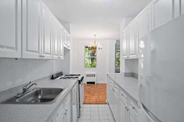 1299 Palmer Ave Unit 218, Larchmont, NY 10538 - kitchen featuring white appliances, radiator, a sink, white cabinets, and a chandelier
