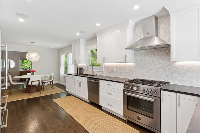 79 Oakside Rd, Smithtown, NY 11787 - kitchen with wall chimney exhaust hood, appliances with stainless steel finishes, dark countertops, dark wood-style floors, and recessed lighting