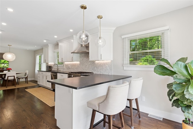 79 Oakside Rd, Smithtown, NY 11787 - kitchen featuring dark countertops, decorative backsplash, white cabinetry, a peninsula, and dark wood-type flooring