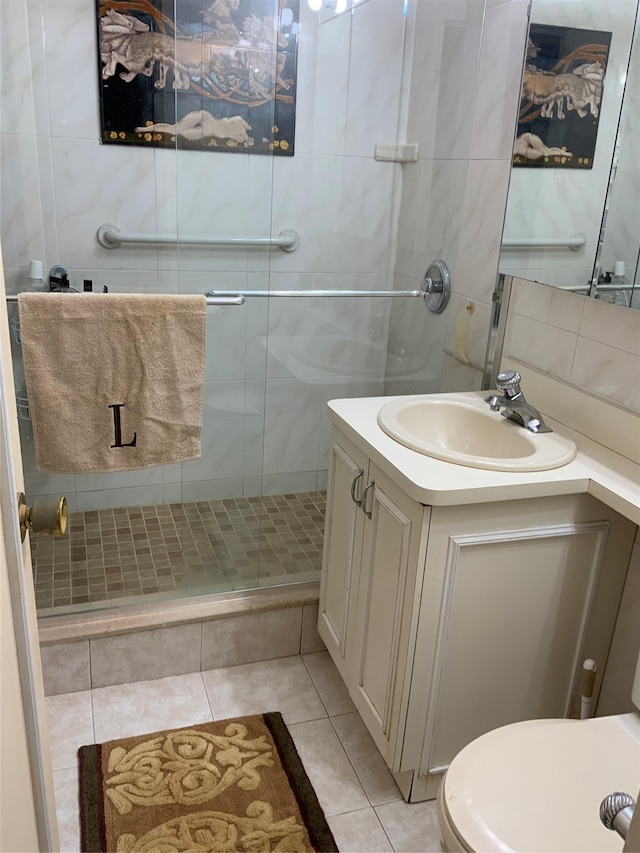 26910 Grand Central Pkwy Unit 8N, Floral Park, NY 11005 - full bath featuring tile patterned floors, a shower stall, vanity, toilet, and tile walls